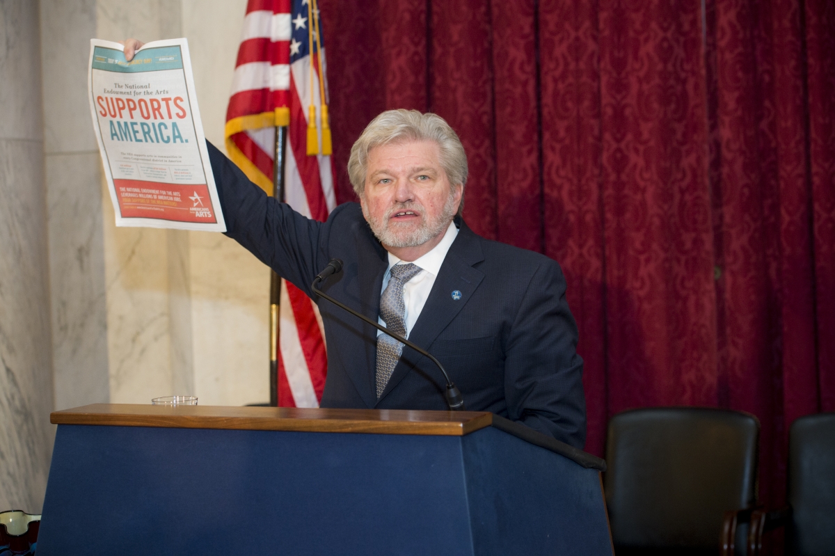 Bob Lynch holds up ads for Arts Advocacy Day that printed in the Capitol Hill newspapers read by members of Congress and staff: Roll Call, Politico, and The Hill. (Photo by Maria Bryk.)