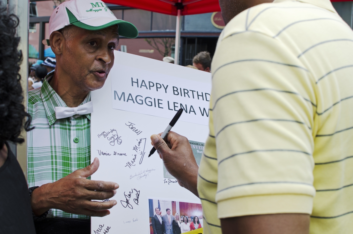 Melvin Jones passes around a birthday card for Maggie Walker at the unveiling of her monument. Photo by Haley Harrington, Oakwood Arts.