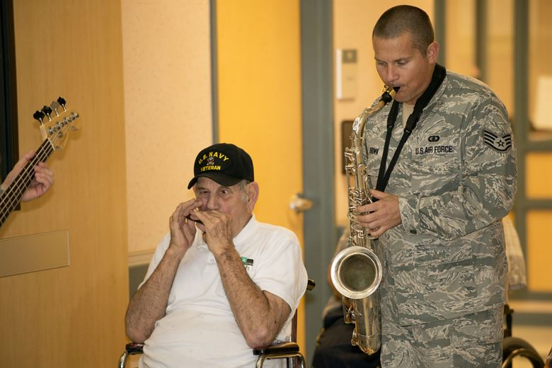 A veteran breaks out the harmonica and jams with an Air Force Musician. (Photo: U.S. Air Force Global Strike Command Public Affairs)