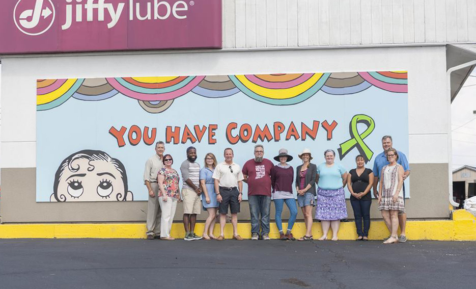 The message “You Have Company” on this mural, designed by Ellen Forney and painted by the community, refers to the often-invisible challenge of mental illness, which seems isolating to its those who are suffering.