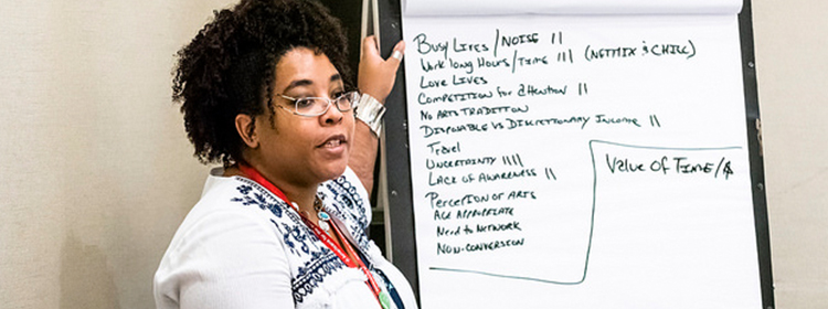 Photo of woman who is taking notes on large poster paper in a conference session