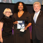 Kristina Newman-Scott receives the Selina Roberts Ottum Award in 2018. She is flanked by Americans for the Arts Board Chair Julie Muraco and CEO Robert L. Lynch.