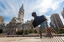A large sculpture of an Afro pick in front of Philadelphia's city hall building.