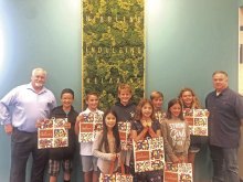 Students pictured holding Gelson's shopping bags that feature their designs.